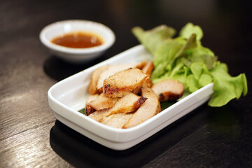 Charcoal-boiled pork neck (grilled pork) served with spicy dipping sauce (Jaew), Thai food recipe.