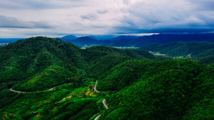 Fototapeta na wymiar Aerial view or drone shot of road thru mountains with green forest in Asia.