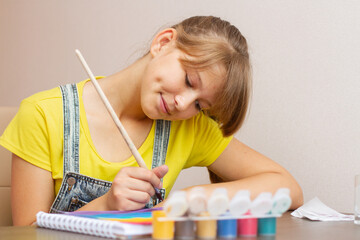 Young girl painting multi colored rainbow. Kid painting