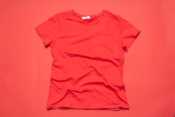 A red t-shirt on a red flat lay background.