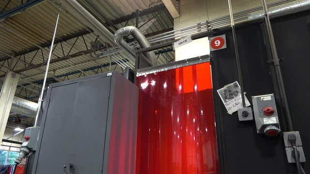 Wide shot of arc flashes coming from a welding booth.