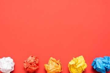 Crumpled paper leaf ball on the red flat lay background with copy space.