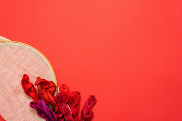 Hoop and floss on the red flat lay background with copy space.