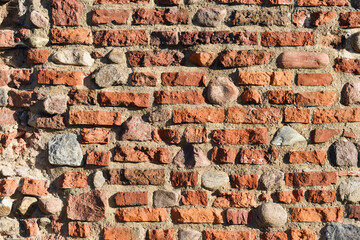 Dark red bricks and small stones wall