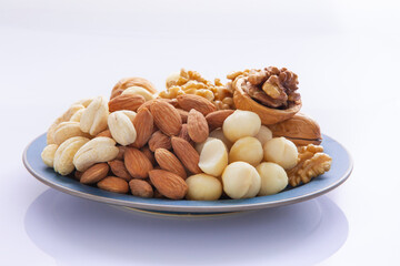 Nutritious mixed nuts on the plate, walnuts, almonds, cashews, macadamia nuts
