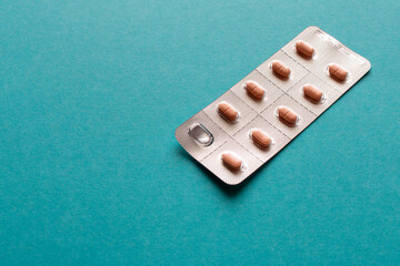 Package of pills on a blue background. Close up. Selective focus.
