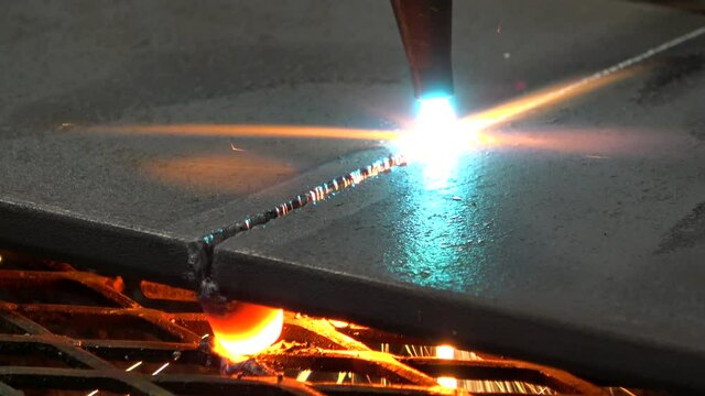 A torch manually cuts through a piece of metal.