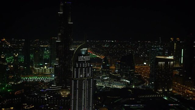 A mesmerizing aerial shot of The Address with the magnificent Burj Khalifa in downtown Dubai with the beautiful glimmering night light. 6-axis stabilized gimbal, Shotover F1, 8K, parallax.