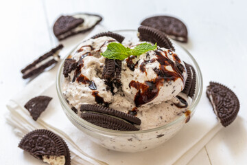 Chocolate cookie and ice cream in a glass bowl with mint leaf on white wooden background, summer sweet and dessert