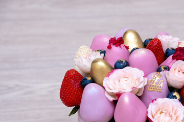 The most beautiful bouquet of fresh strawberries in white, pink and gold chocolate on a light background.