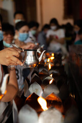 Making merit according to beliefs in the temple Ayutthaya, Thailand, Wearing a face mask.
