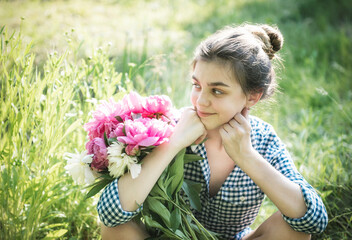 Fototapeta premium Beautiful girl with a bouquet of peonies