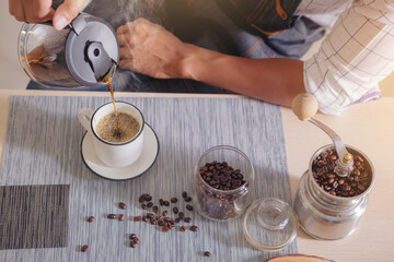 Top view of Handsome man filling mug with hot fresh coffee in a morning at home