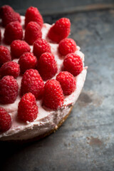 Fresh cheesecake with raspberries on the rustic background. Selective focus. Shallow depth of field. 