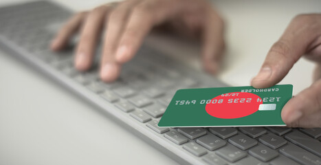 Man pays online with plastic bank card with printed flag of Bangladesh. Fictional numbers