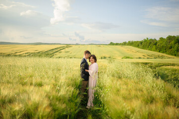 Fototapeta na wymiar Adult couple in a green wheat field.