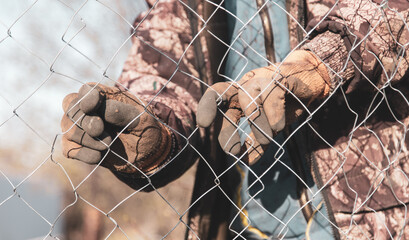 A man sets a metal mesh on the fence.