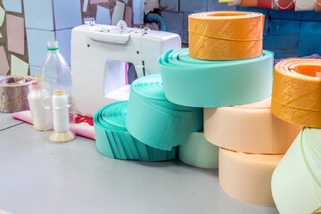 Automatic sewing machine and ribbons on tailor's workplace.