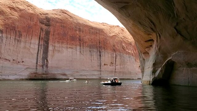 Lake Powell Utah boats inside cave Amphitheater shore. Reservoir Colorado River. Vacation hiking, boating, outdoors recreation. Glen Canyon Dam. Marinas for boats, houseboats, fishing adventure fun.