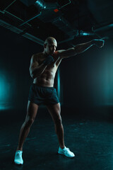 Confident man training boxing stance while being alone