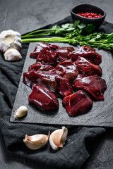 Raw Turkey liver on a stone Board. Black background. Top view