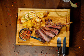 fried potatoes with meat on a plate on a wooden table.Top view