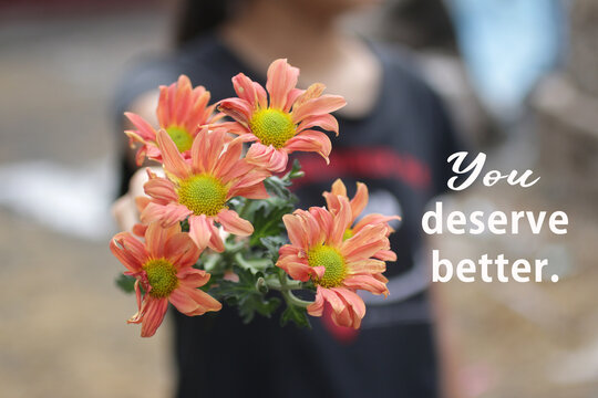 Inspirational motivational quote - You deserve better. With young girl holding and showing beautiful bouquet of peach dahlia flowers plant in hands. Self respect and happiness concept.