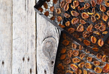 Procurement of dried apricots for future use.Dried apricots in a rack from the dryer on a wooden natural table.