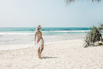 Happy traveller woman in white enjoys her tropical beach vacation in sunny day. Holidays, Travel, Coastline, Freedom concept.
