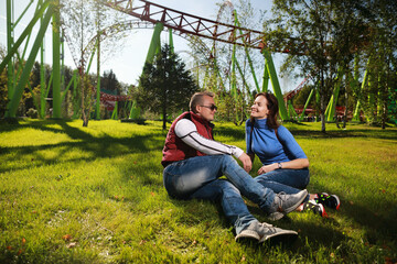 Man and woman happiness together in amusement park at American roller coaster attraction...