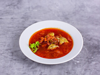 Borscht with greens on the background