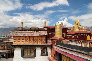 Fototapeta na wymiar Gilded bell and Wheel of Dharma on the top of the roof at Jokhang Temple in Lhasa, Tibet, China