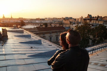 man and woman siting on rooftops historic center St. Petersburg and enjoying with  amazing sunset.