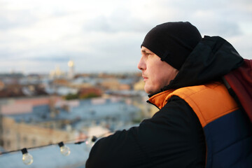 A man sitting on rooftops during amazing sunset.