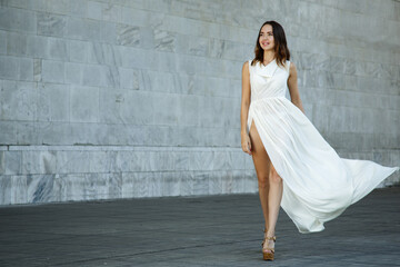 Beautiful fashion woman in a long white dress. walk around the city