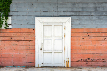 Old closed wooden white door with colorful wood wall for concept background and texture.