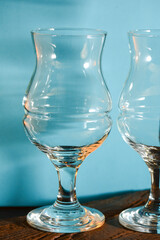 Two empty beer glasses over blue background.