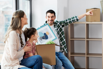 mortgage, family and real estate concept - happy mother, father and little daughter with stuff in boxes moving to new home