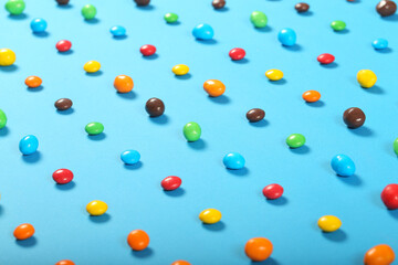 dragee candy of different colors lies on a bright background