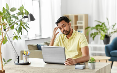 technology, remote job and business concept - disappointed indian man with laptop computer working at home office
