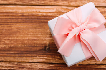 Beautiful gift box with altas bow on a vintage wooden board. holiday card concept.