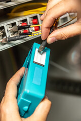 A man cleans the fiber optic cable connectors with a special blue cleaner. Cleaning connectors...