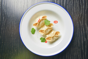 Close up fresh boiled dumplings with hot steams on white ceramic plate. Chinese food, Asian cuisine.