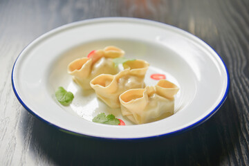 Close up fresh boiled dumplings with hot steams on white ceramic plate. Chinese food, Asian cuisine.