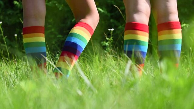 children girl and boy in rainbow striped socks playing in the street on the grass
