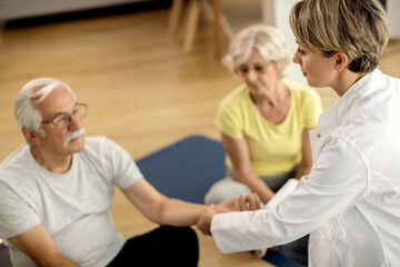 Fototapeta premium Physical therapist and senior couple during home workouts.