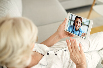Close-up of senior woman having video call with her doctor over a touchpad.