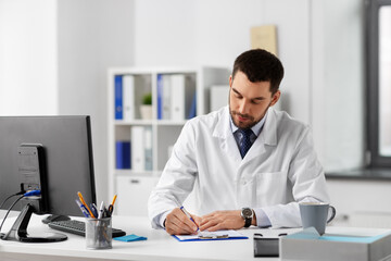 Fototapeta premium healthcare, medicine and people concept - male doctor with clipboard at hospital