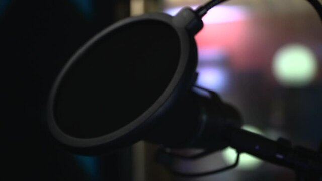 Moving slowly around the studio mic covered with a pop filter. Extreme close up
