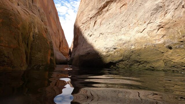 Swimming through flooded slot canyon Lake Powell Uta. Reservoir on Colorado River. Vacation hiking, boating, outdoors recreation. Glen Canyon Dam. Marinas for boats, houseboats, fishing adventure fun.